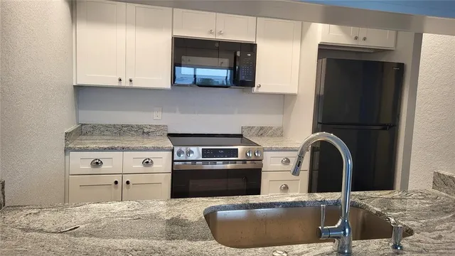 a kitchen with a sink stove and cabinets