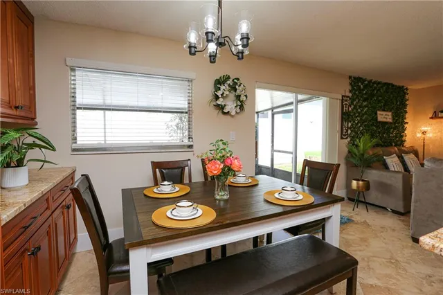 a view of a dining room with furniture a chandelier and a window