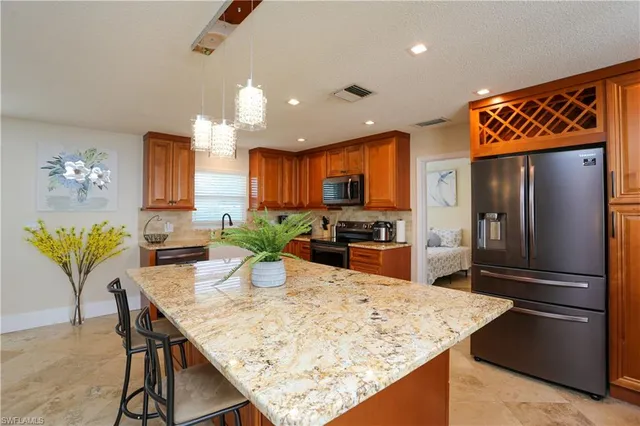 a kitchen with stainless steel appliances wooden floor dining table and chairs