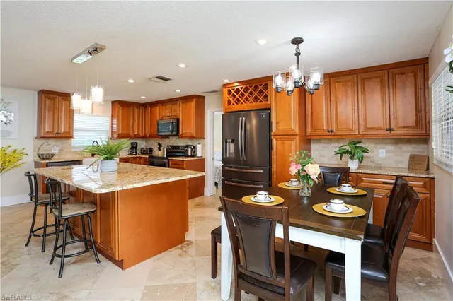 a kitchen with a table chairs refrigerator and cabinets