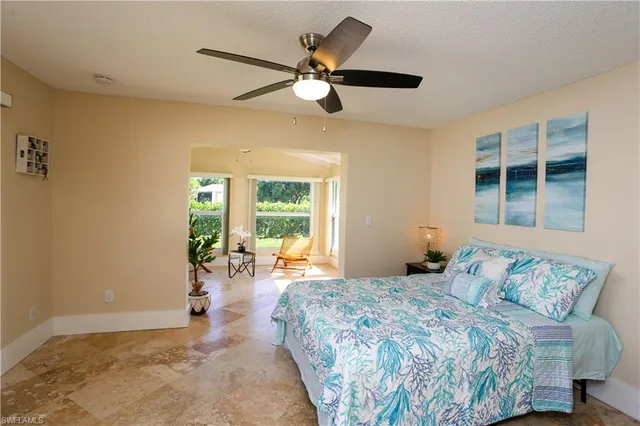 a bedroom with a bed and a large window