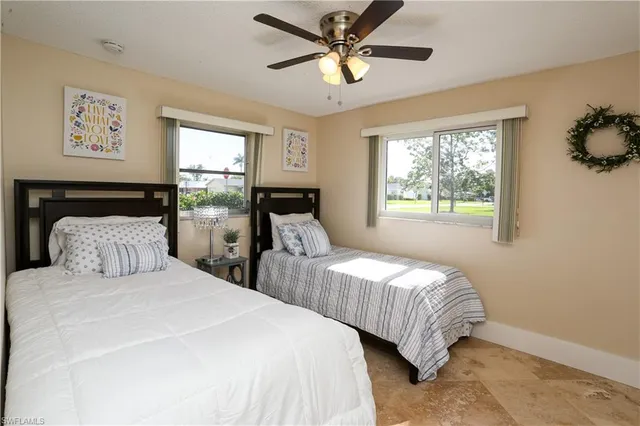 a bedroom with two large bed and a window