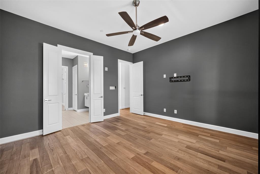 5015 Meridian Lane, Unit 2102 Addison, TX 75001 - Photo 17 of 36 Spacious room featuring wood-finish flooring and dark gray walls