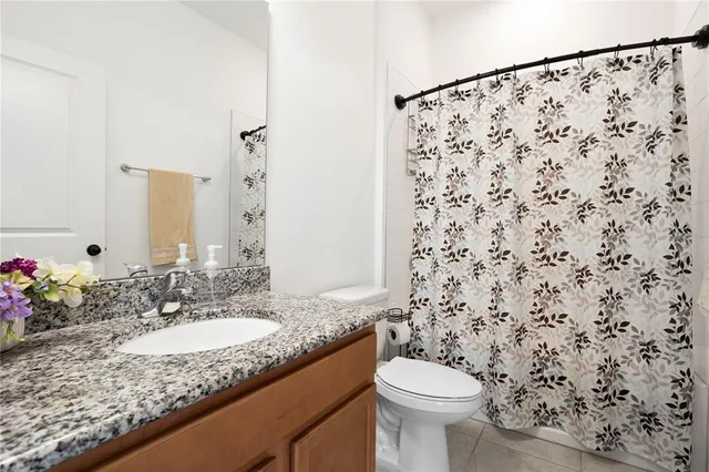 a bathroom with a granite countertop sink a toilet and a mirror