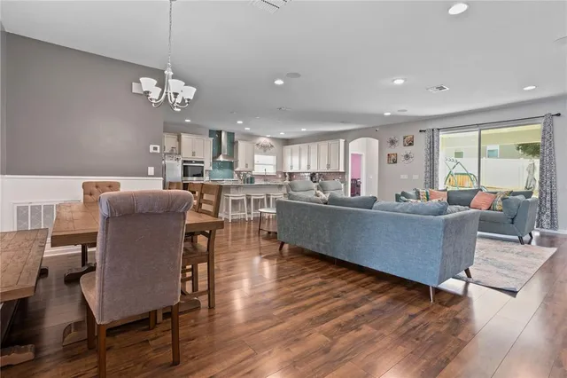 a living room with furniture kitchen and a chandelier
