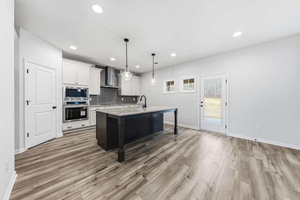 75 Oak Ridge Drive Waverly Hall, GA 31831 - Photo 13 of 40 a large kitchen with stainless steel appliances kitchen island a large counter top and a refrigerator