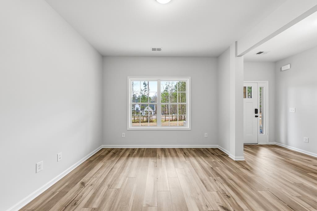75 Oak Ridge Drive Waverly Hall, GA 31831 - Photo 7 of 40 a view of an empty room with wooden floor and a window