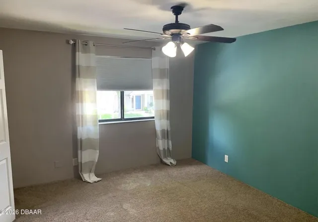 en empty room with windows and fan