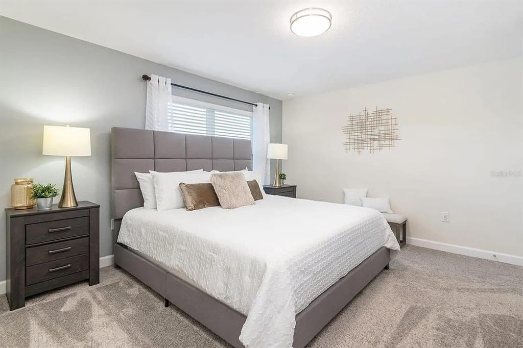 400 Ocean Course Avenue Davenport, FL 33896 - Photo 11 of 34 a bedroom with a bed and a lamp