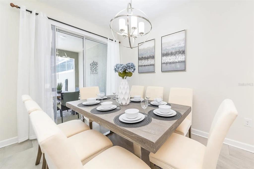 400 Ocean Course Avenue Davenport, FL 33896 - Photo 5 of 34 a view of a dining room with furniture wooden floor and chandelier