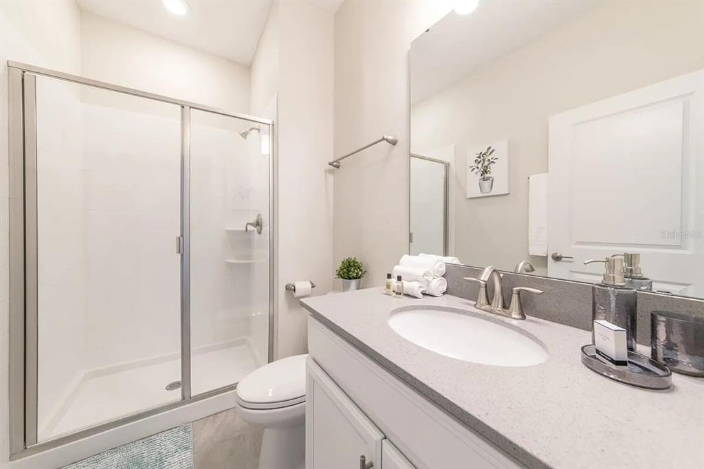 400 Ocean Course Avenue Davenport, FL 33896 - Photo 9 of 34 a bathroom with a double vanity sink toilet and shower