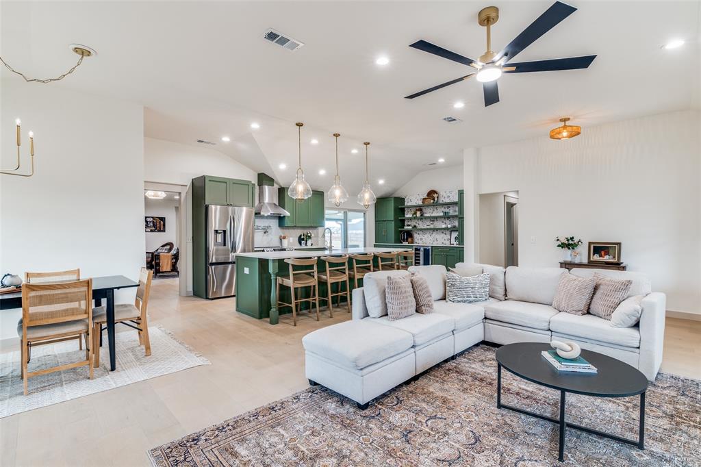 a living room with furniture kitchen view and a chandelier