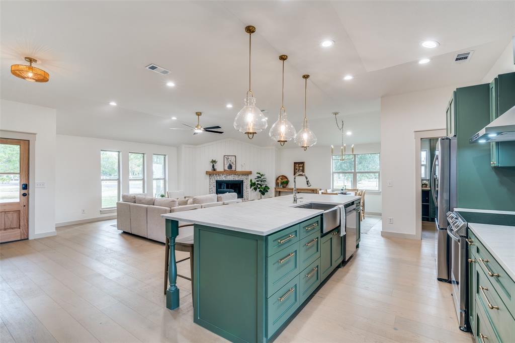 5109 Old Gate Lane Parker, TX 75002 - Photo 4 of 24 a kitchen with kitchen island a sink stove and wooden floor