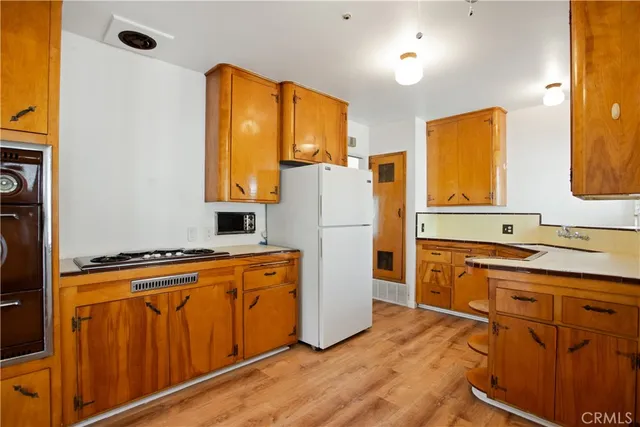 a kitchen with wooden cabinets and refrigerator