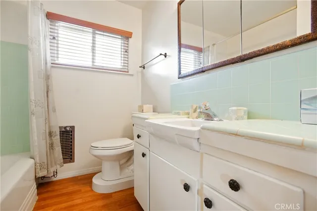 a bathroom with a sink toilet and window