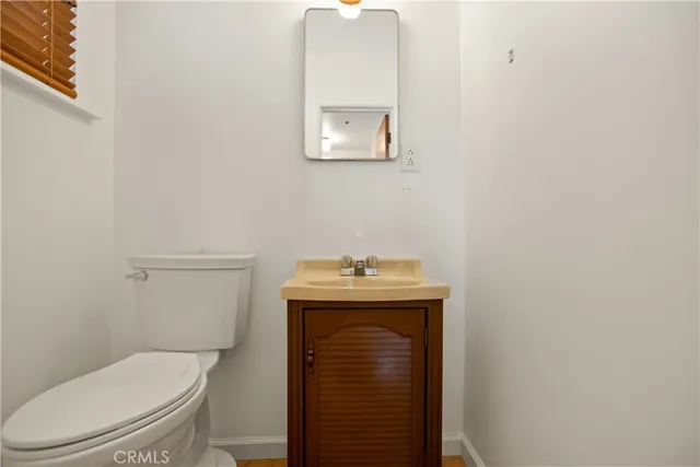 a bathroom with a toilet a sink and mirror