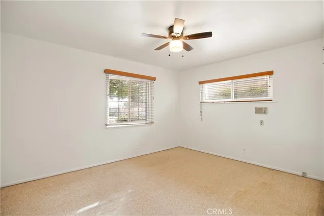 a view of a big room with windows and chandelier fan