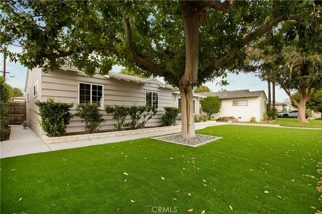 a view of a house with a yard and tree