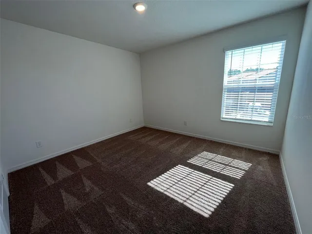 an empty room with wooden floor and a window