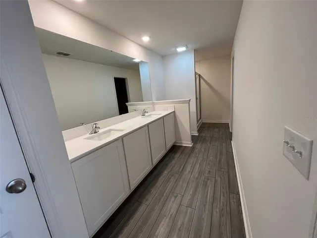 a view of hallway with stairs and wooden floor