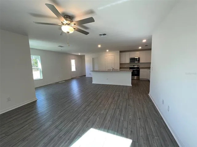 a view of a kitchen and an empty room