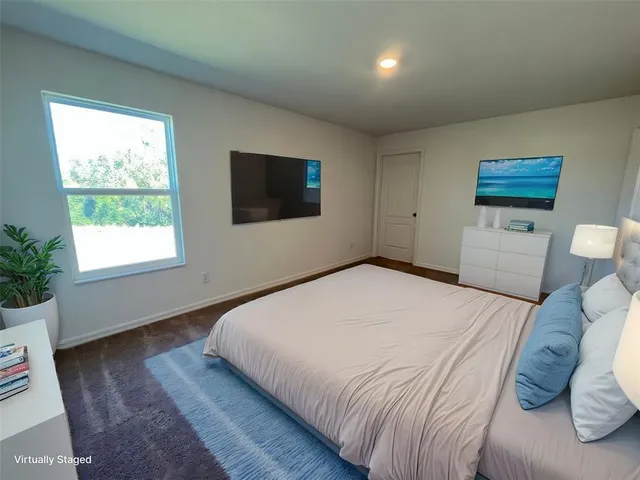 a bedroom with a large bed and a tv