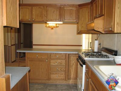 11357 Eaby Road Phelan, CA 92371 - Photo 8 of 18 a kitchen with stainless steel appliances granite countertop a sink stove and refrigerator