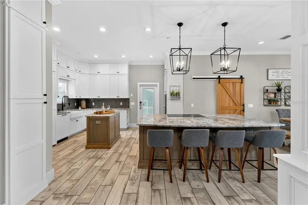 a kitchen with granite countertop kitchen island stainless steel appliances and white cabinets