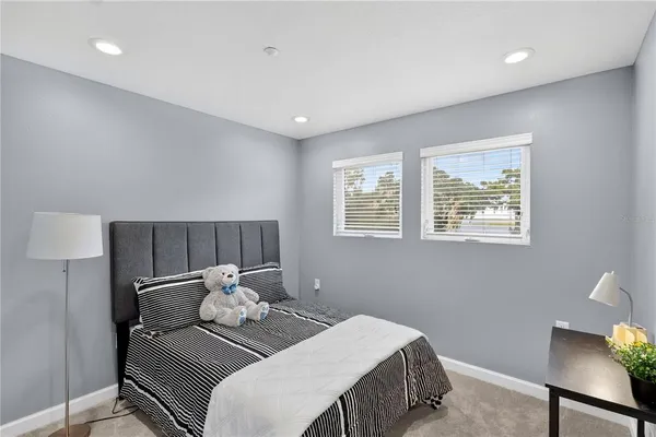 a living room with stainless steel appliances furniture a rug and a kitchen view