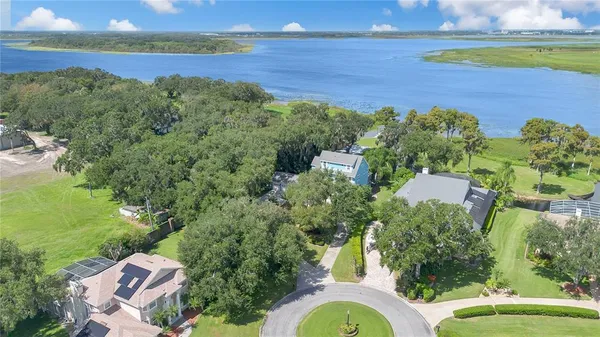 an aerial view of residential houses with outdoor space and trees all around