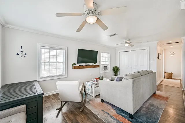 a living room with furniture a flat screen tv and a window