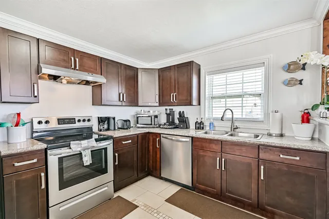 a kitchen with stainless steel appliances granite countertop a sink stove and cabinets