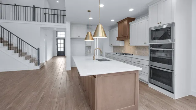 a kitchen with kitchen island white cabinets and stainless steel appliances