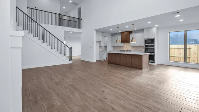a view of kitchen with stainless steel appliances kitchen island wooden floor and living room