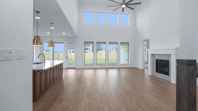 a view of a kitchen with furniture a ceiling fan and wooden floor