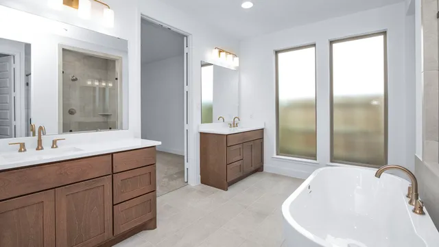 a bathroom with a tub sink shower and mirror