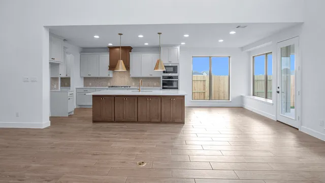 a large kitchen with stainless steel appliances kitchen island granite countertop a large cabinets a sink and a stove