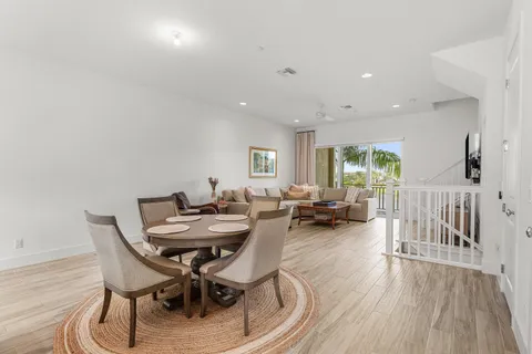 a kitchen with stainless steel appliances granite countertop a sink a stove a refrigerator and white cabinets with wooden floor