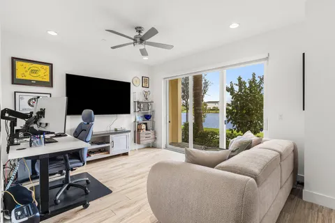 a living room with furniture a flat screen tv and a large window