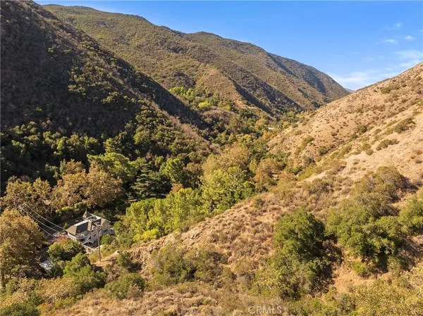 a view of a dry yard with mountains and green space