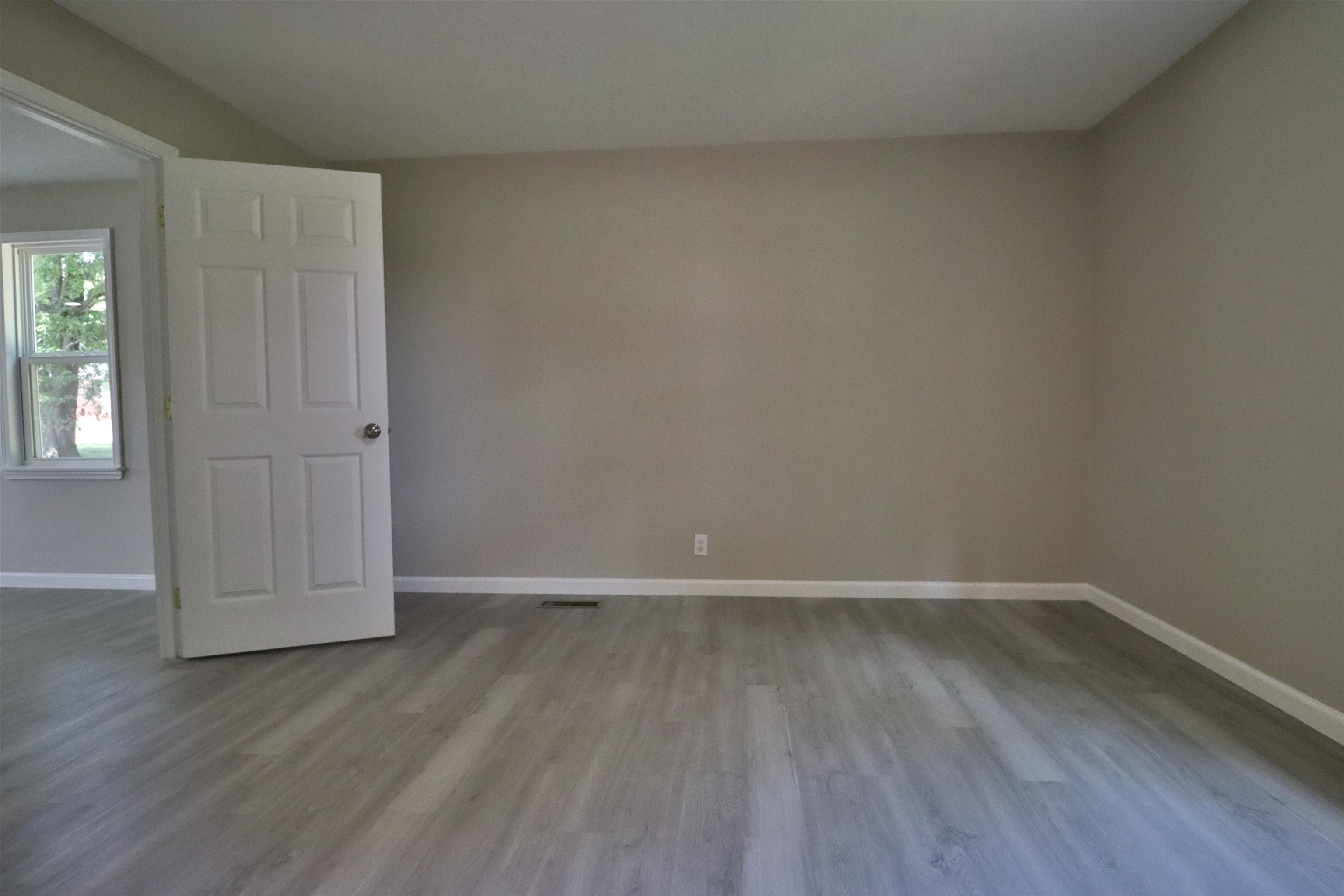 224 Kellar Avenue Ripley, TN 38063 - Photo 14 of 30 an empty room with wooden floor and windows