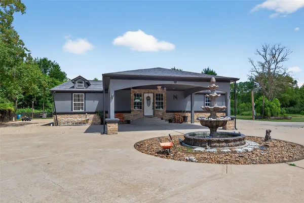 a view of a house with backyard and sitting area