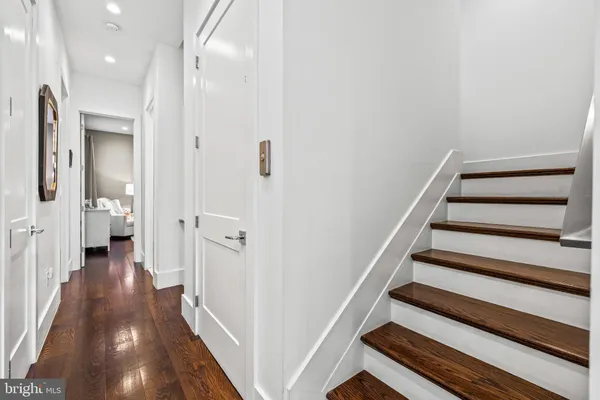 a view of a hallway with wooden floor and staircase