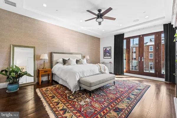 a bed sitting in a spacious bedroom next to a window