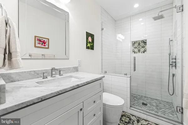 a bathroom with a granite countertop sink toilet and shower