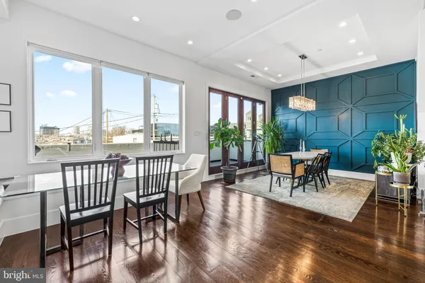 a living room with furniture a potted plant and a large window
