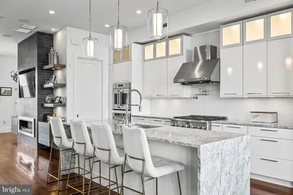 a kitchen with stainless steel appliances granite countertop a sink a stove and a refrigerator