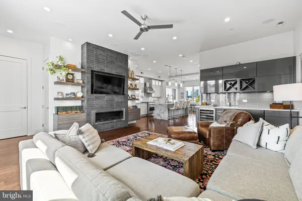 a living room with furniture a fireplace and a ceiling fan