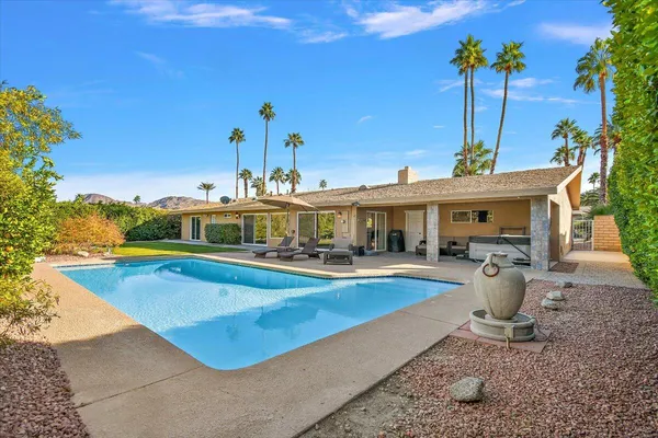 a view of a swimming pool with lawn chairs