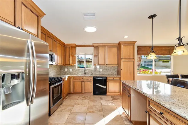 a large kitchen with stainless steel appliances granite countertop a sink and stove